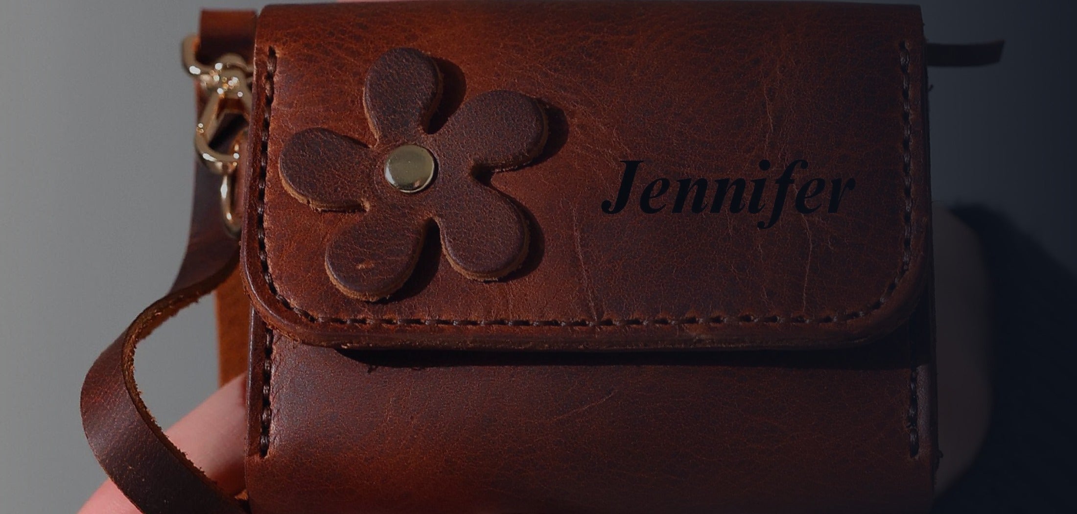 Craftivor leather laptop bag, wallet, and keychain arranged on a dark work table